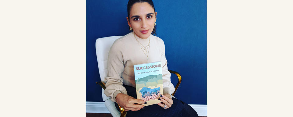 Michaela Di Cesare sits in a chair holding a copy of Successions.