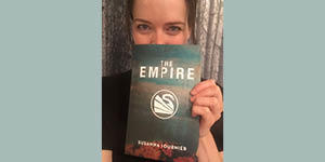 Susanna Fournier holds a copy of The Empire in front of her face.