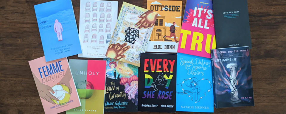 An assortment of books by queer authors lie on a table