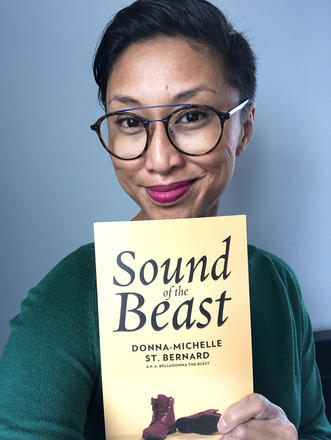 Catherine Hernandez holds a copy of Sound of the Beast